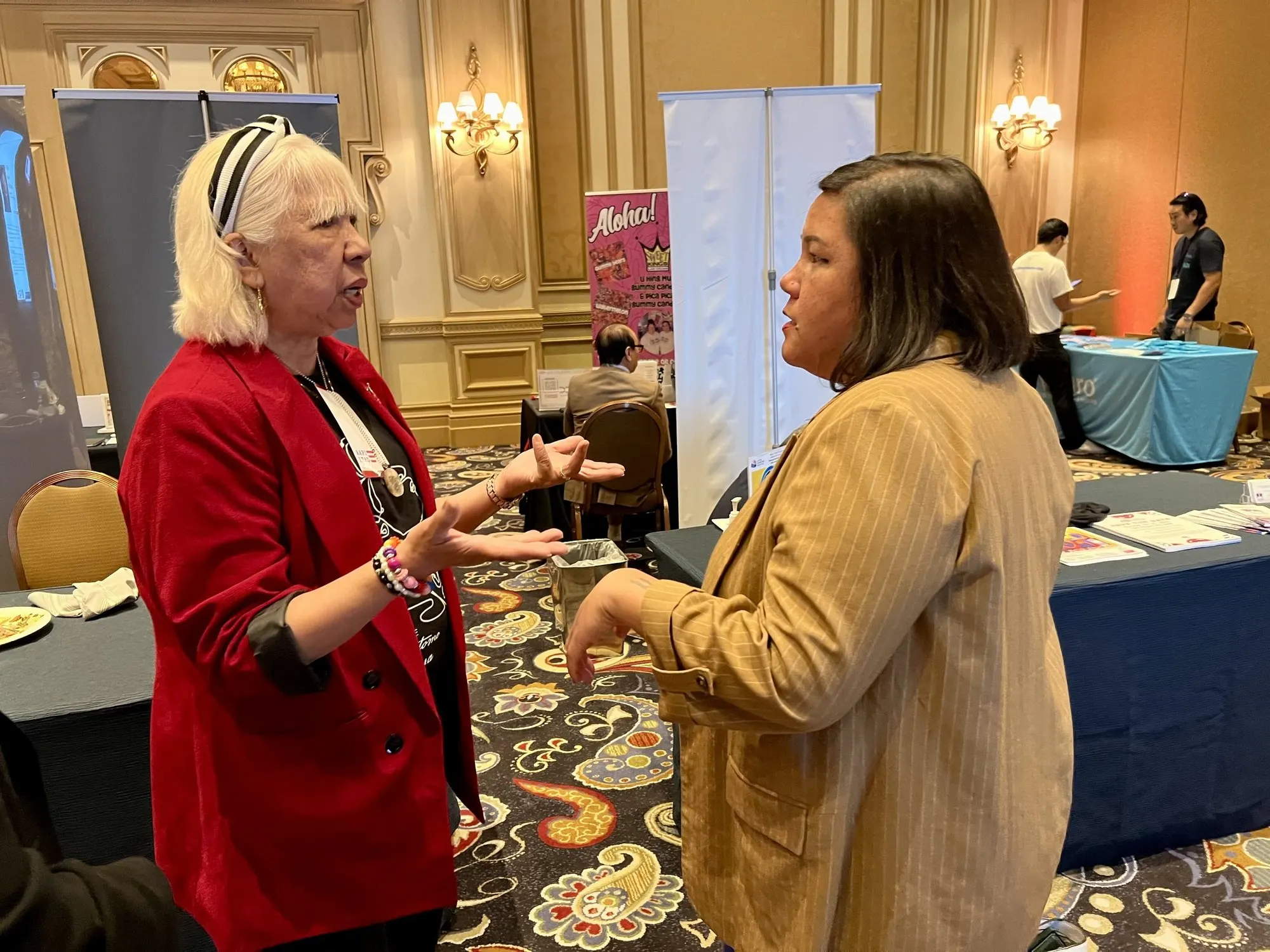 Margie talking with a guest at an expo