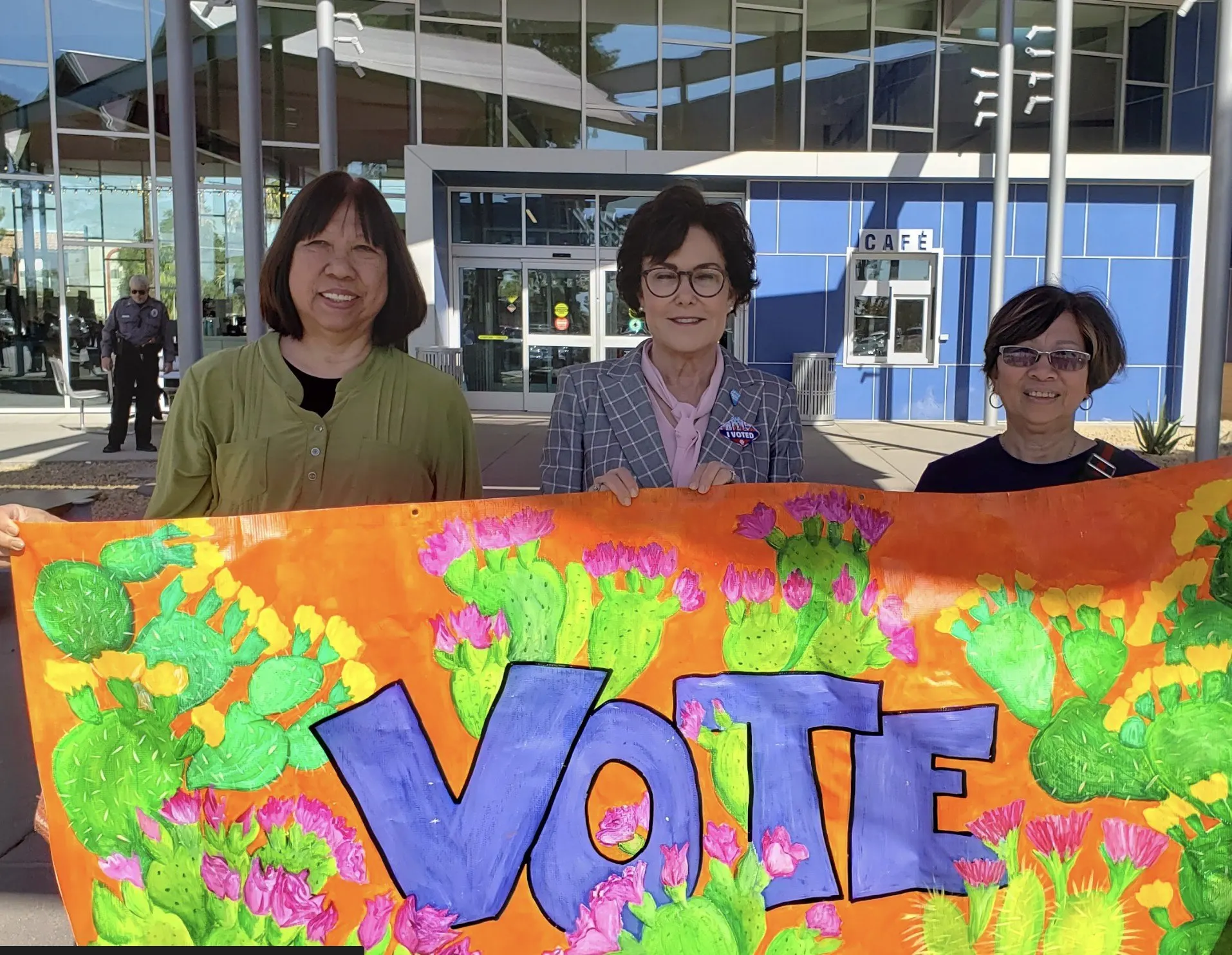 Volunteers holding a colorful VOTE banner